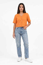 Women's orange cropped blouse with short sleeves and button front, eyelet pattern