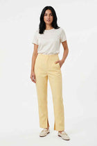 Yellow split-hem trousers on model, high-rise with belt loops and concealed fly