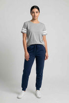 Light grey women’s short-sleeve T-shirt worn by a model with dark blue pants