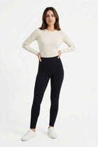 Black women's stretch leggings on model, full-length with ankle hem