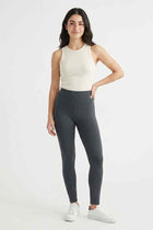 Women's dark grey stretch leggings on model, full front view, ankle-length