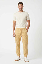Beige cargo jogger pants worn by a man, front view with cargo pockets and cuffed ankles