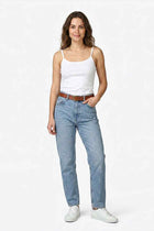 White women’s basic tank top worn with light blue jeans; thin straps and scoop neck