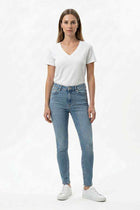 Women's white V-neck T-shirt worn with light blue jeans, short sleeve top