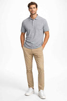 Men's dark grey polo shirt on model, short sleeves, button placket, ribbed collar
