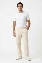 Men's cream elastic-waist regular-fit pants, side view with front crease and pockets.