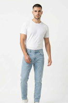 Men's light blue skinny fit jeans on model, straight skinny legs, button fly
