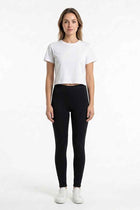 Black women's stretch leggings worn, full-length skinny leg and elastic waistband