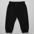 Black baby jogger trousers flat lay, elastic waistband and cuffed tapered legs