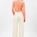 Peach velvet wrap blouse shown from back, long sleeves and cropped cut