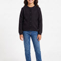 Black knit cardigan for girls with long sleeves and button-front, paired with jeans