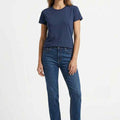 Women’s navy crew neck T-shirt worn with blue jeans and white sneakers.