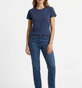 Women’s navy crew neck T-shirt worn with blue jeans and white sneakers.