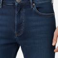 Dark blue slim-fit jeans waistband with button closure and coin pocket