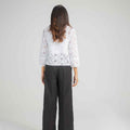 Women's embroidered basic shirt with 3/4 sleeves and black wide-leg pants, back view