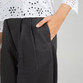 Women's embroidered basic shirt with 3/4 sleeves; hand in pocket on black pants