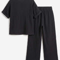 Black textured short-sleeve top and wide-leg pants, elastic waistband with tie