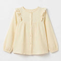 Girls ecru blouse with ruffle trim and bow accents at shoulders, long sleeves