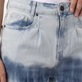 Denim shorts close-up: ombre tie-dye wash, front pockets, metal button and zipper