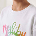 Girls' white sweatshirt close-up of colorful Malibu script logo