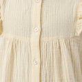 Girls ecru blouse front placket with white buttons and ruffled collar
