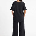 Black textured set, back view of short-sleeve top and wide-leg pants