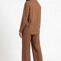 Women's brown co-ord set, side view: button-up shirt with wide-leg trousers.