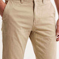 Men's slim-fit beige chinos detail: zip fly, front pockets, and belt loops