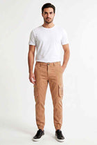 Men's tan cargo trousers on model with side cargo pockets and elastic ankle cuffs