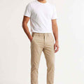 Men's slim-fit chinos in light beige, front view with belt loops and button closure