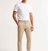 Men's slim-fit chinos in light beige, front view with belt loops and button closure