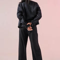 Womenâ€™s short dark blazer, back view with long sleeves and relaxed shoulders